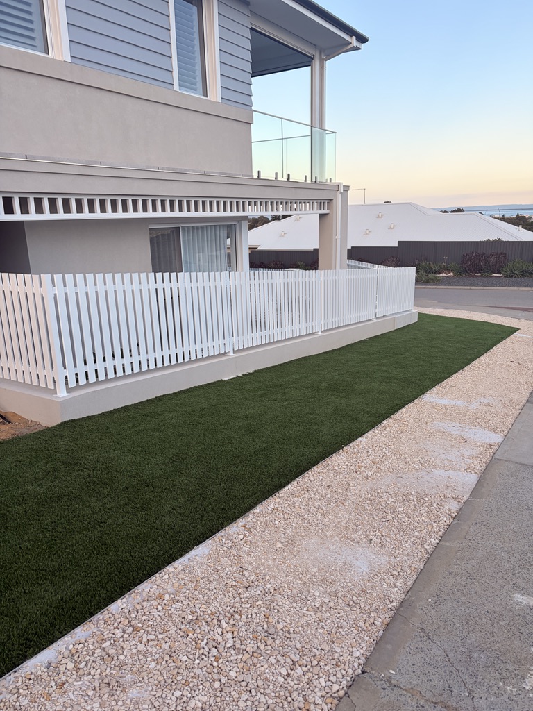 White aluminium picket fencing on double-storey home by QP Fencing