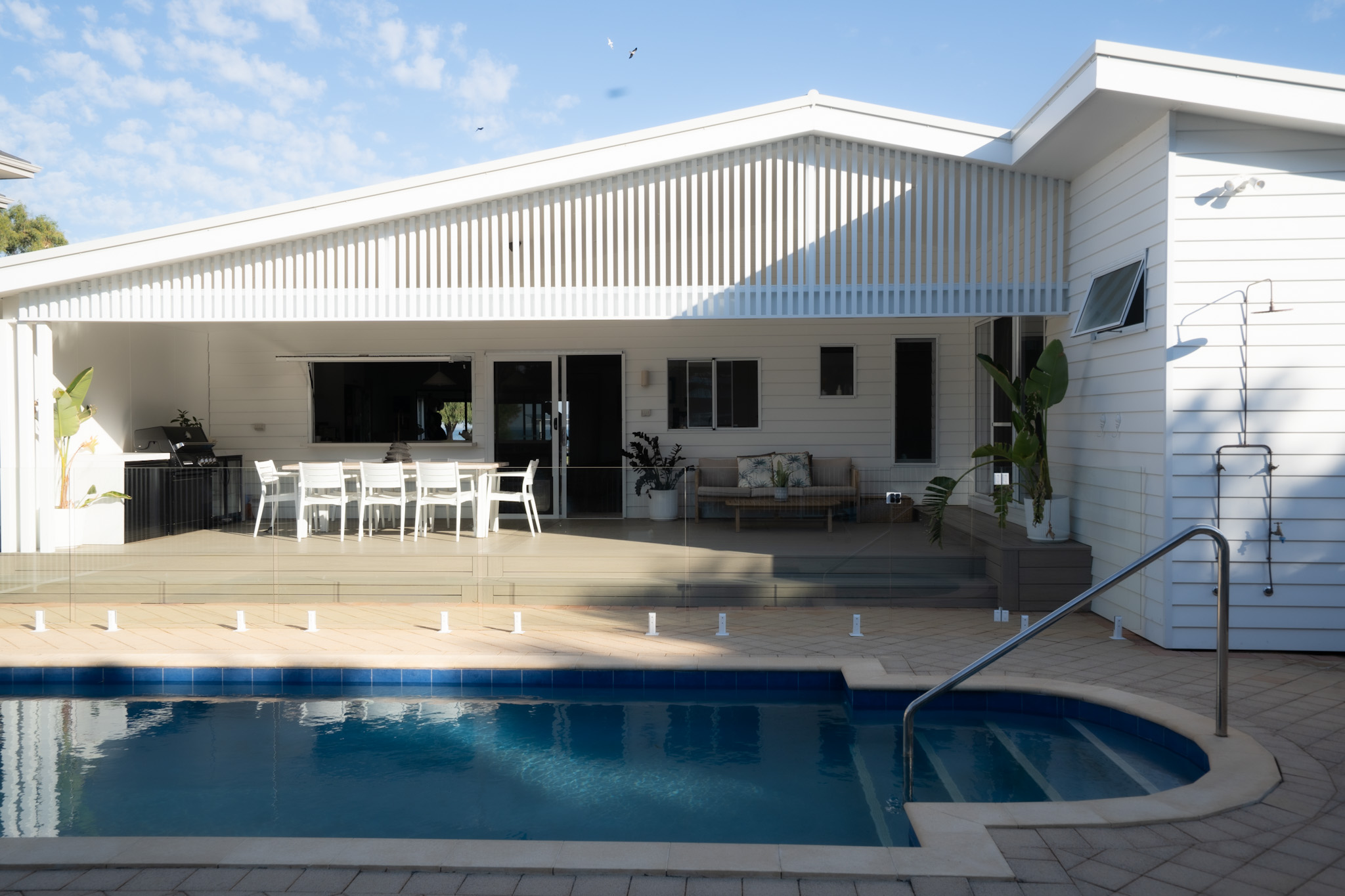 Premium white house with glass pool fencing by QP Fencing & Gates